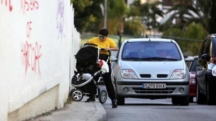 La acera de la calle del Mar, de apenas 50 centímetros de anchura, impide circular con un carro de bebé -como se aprecia en la imagen- o con una silla de ruedas.