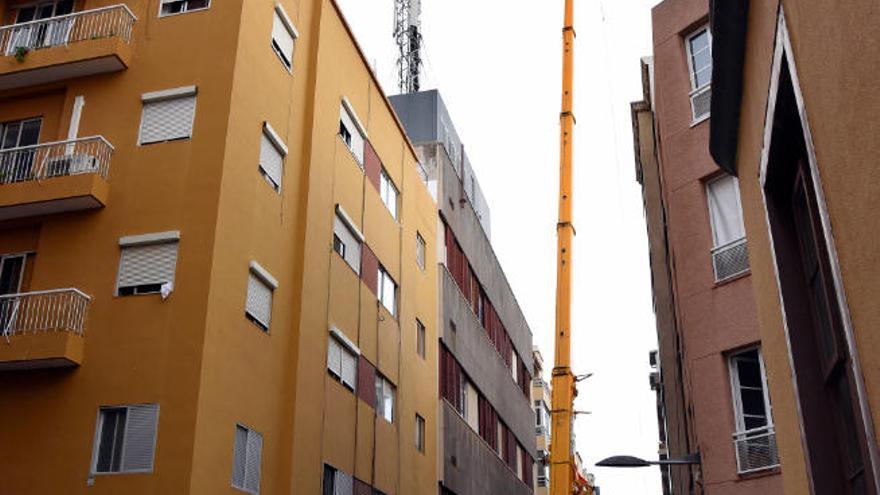 La grúa de grandes dimensiones ocupa casi todo el ancho de la calle.