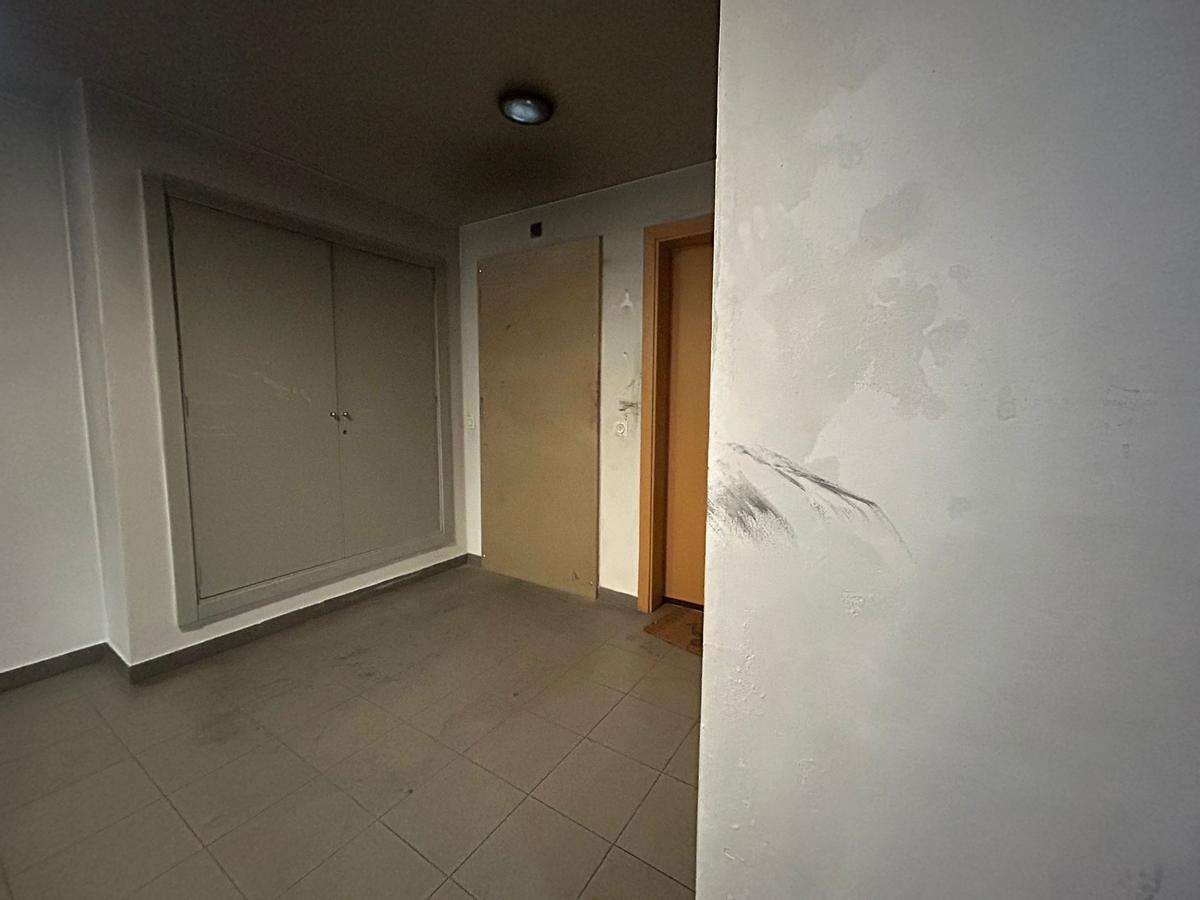 La puerta de entrada de la vivienda incendiada, sustituida por un tablón de madera.