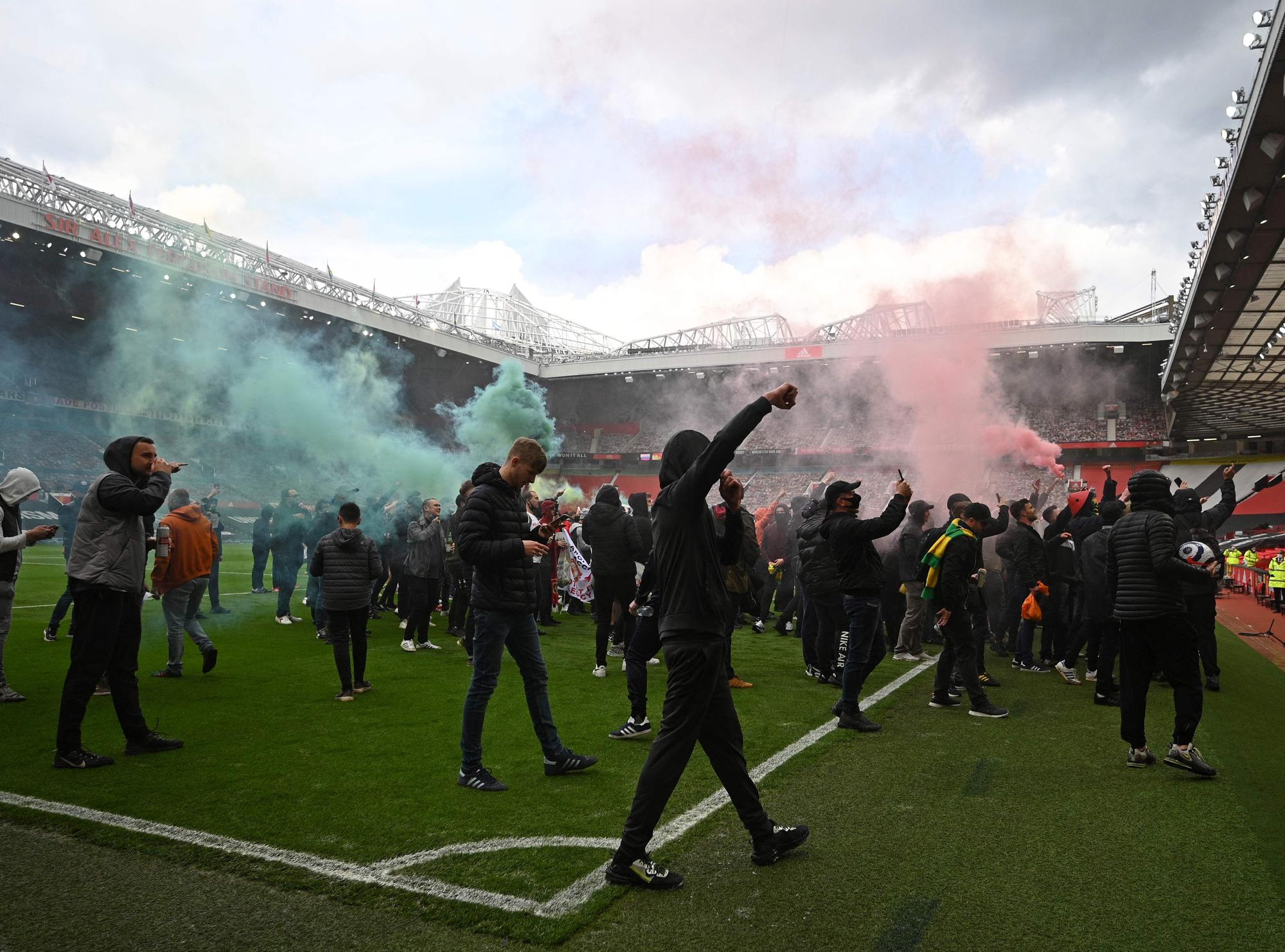 Los seguidores del United, en el césped de Old Trafford.