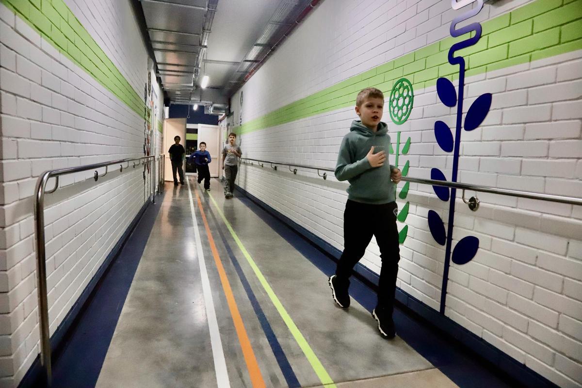 Varios niños corretean por un pasillo del Colegio 124 de Járkov (también conocido como Safe School), construido bajo tierra para proteger a estudiantes y profesores de los bombardeos rusos.