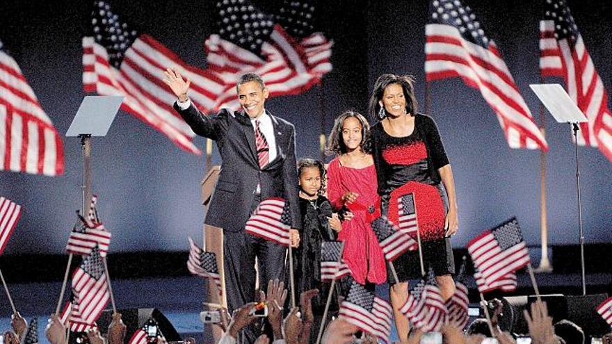 El candidato demócrata Barack Obama, tras conocer su victoria en las elecciones presidenciales, saluda a los asistentes a la fiesta en el Grant Park de Chicago, en compañía de su esposa Michelle y de sus hijas Natasha (2ª i.) y Malia (2ª d.).