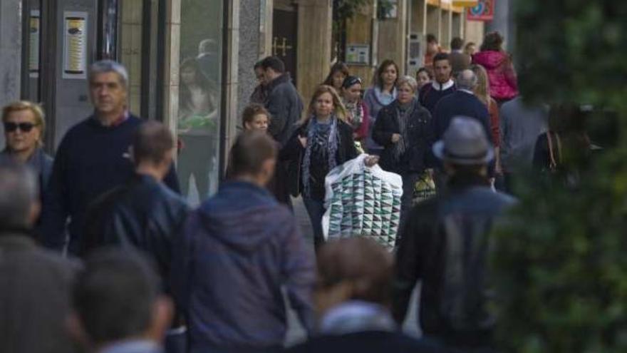 Viandantes por una de las calles con más tiendas y negocios de la ciudad.