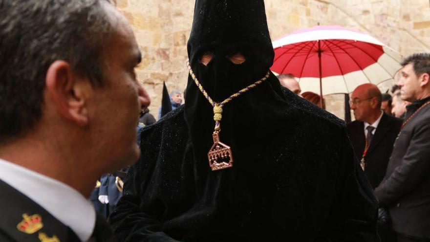 Uno de los hermanos de la Cofradía del Santo Entierro durante los instantes previos al desfile que finalmente tuvo que ser suspendido por la lluvia.