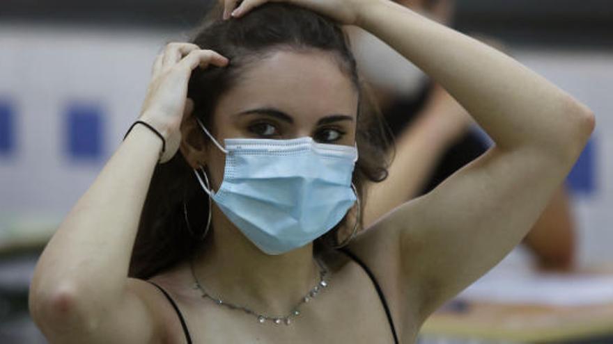 Una joven con una mascarilla de un solo uso.