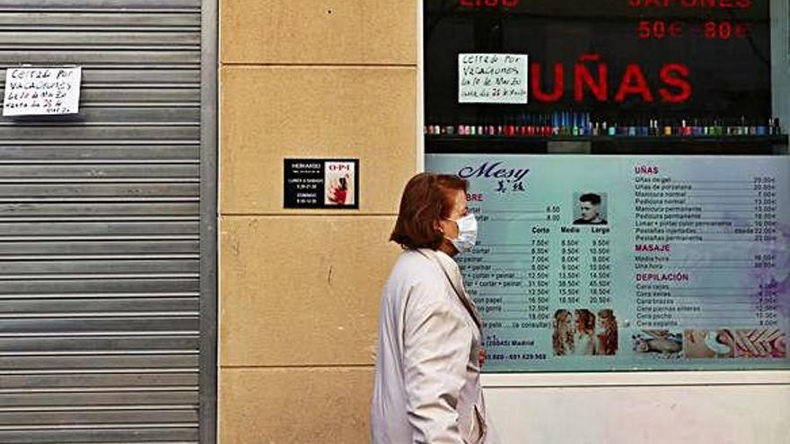 Una dona, amb màscara, passeja per Madrid