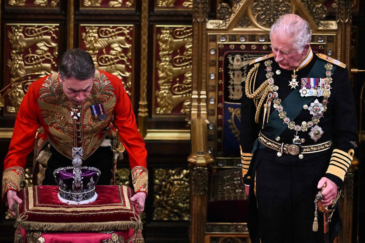 Príncipe Carlos de Inglaterra. En esta foto de archivo tomada el 10 de mayo de 2022, el Príncipe Carlos, Príncipe de Gales (derecha) de Gran Bretaña observa cómo se quita la Corona del Estado Imperial (izquierda) después de leer el discurso de la Reina en la Cámara de los Lores durante la Apertura Estatal del Parlamento en la Casas del Parlamento, en Londres. 