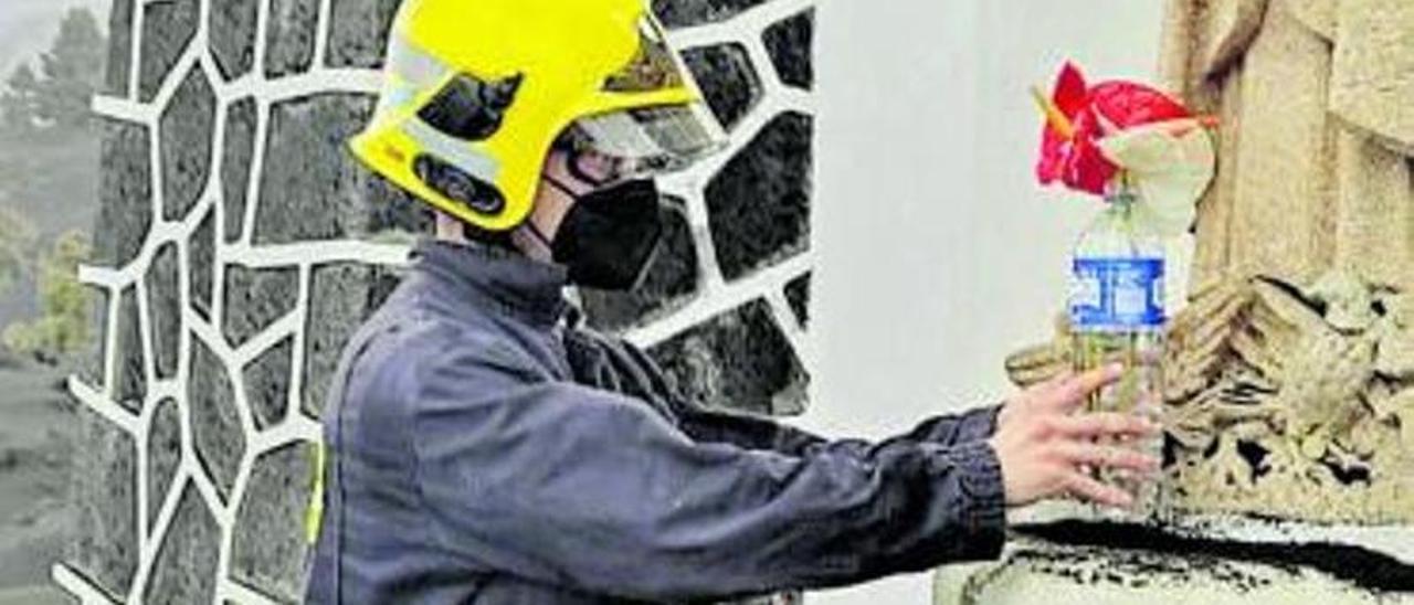 Un bombero deposita la flor a los pies del monumento religioso. | | E.D.