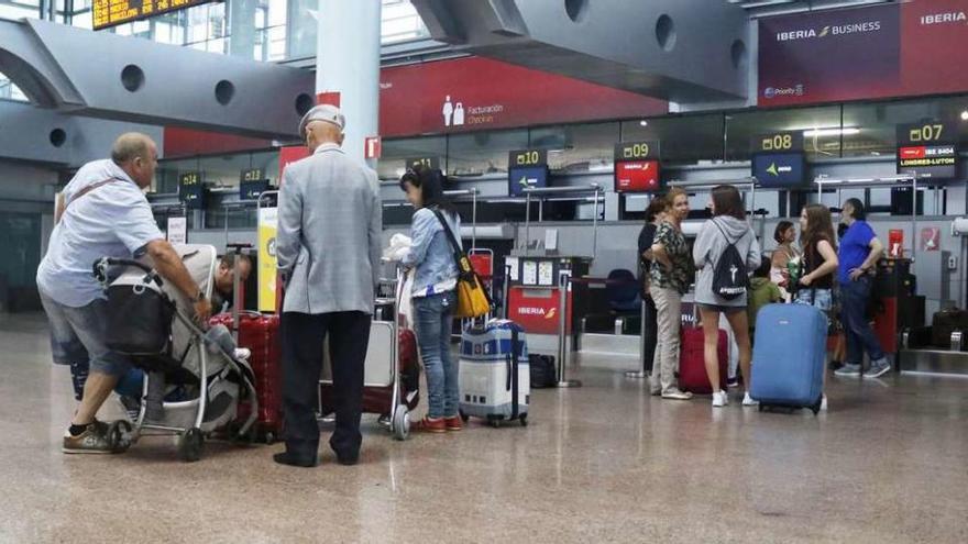 Pasajeros momentos antes de facturar sus maletas para el vuelo a Londres. // Fotos: Alba Villar