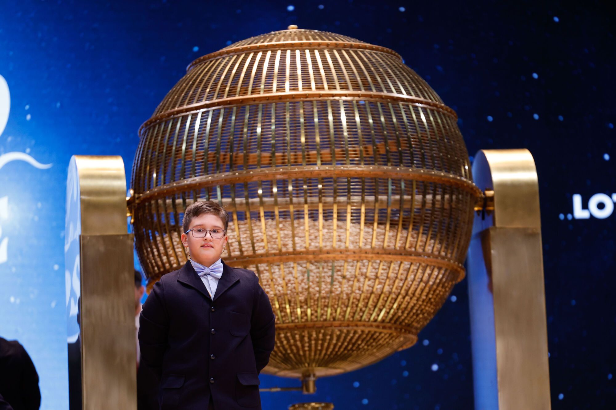 MADRID, 22/12/2024.- Adam Lucas, uno de los niños de la Residencia San Ildefonso de Madrid encargado de cantar los números de la primera tabla, durante el sorteo de la Lotería de Navidad que se celebra este domingo en el Teatro Real, en Madrid. EFE/Javier Lizón