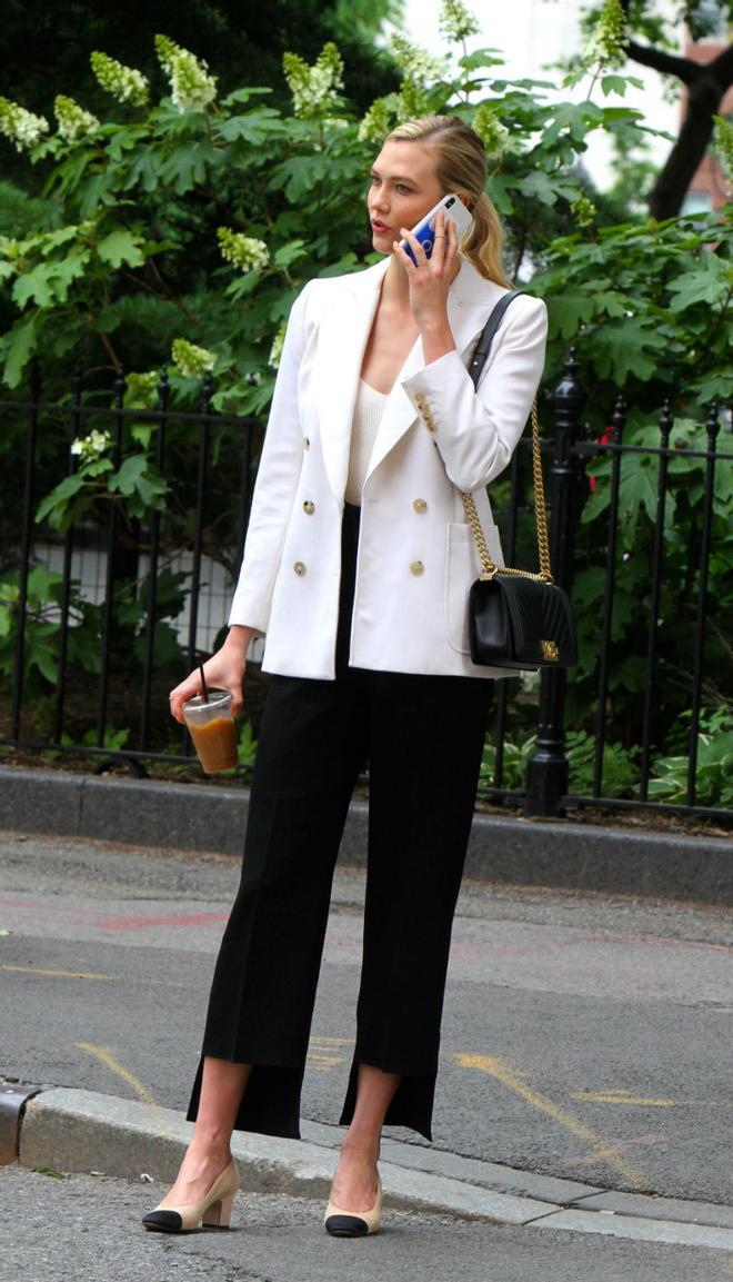 Karlie Kloss con pantalones de bajo asimétrico y blazer blanca