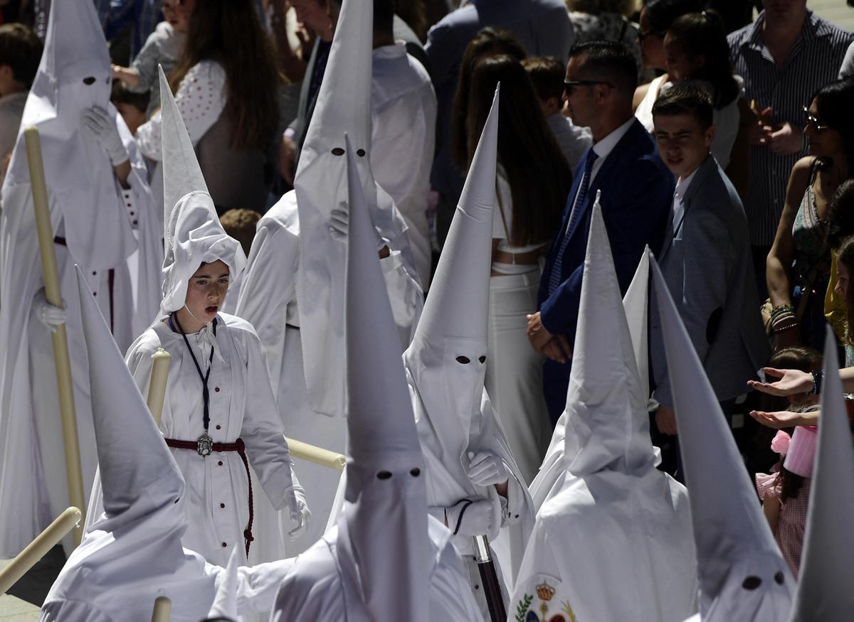 Penitentes de la hermandad de La Paz participan en la procesión del Domingo de Ramos en Sevilla