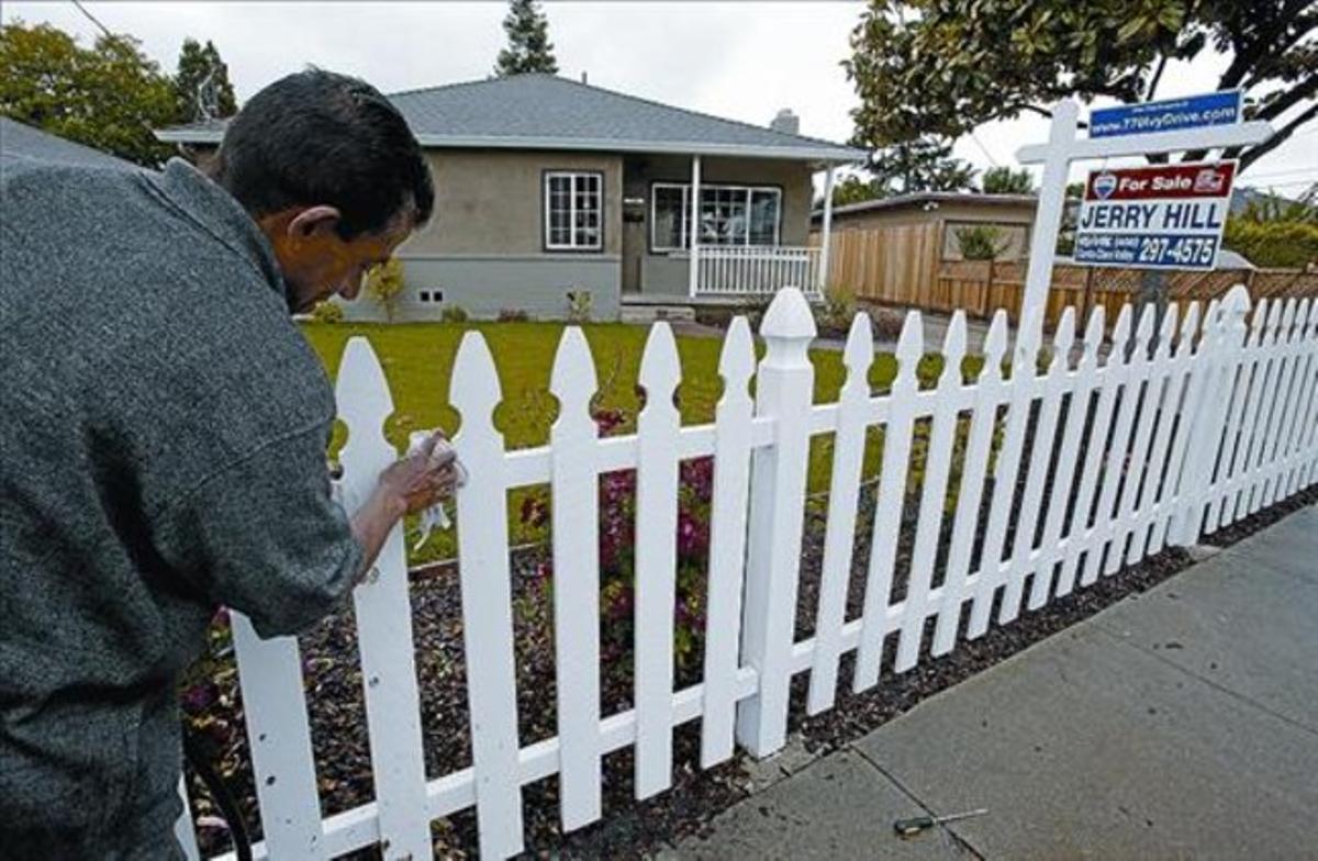 Un home neteja la tanca d’una casa en venda a East Palo Alto (Califòrnia), la setmana passada. Un home neteja la tanca d’una casa en venda a East Palo Alto (Califòrnia), la setmana passada.