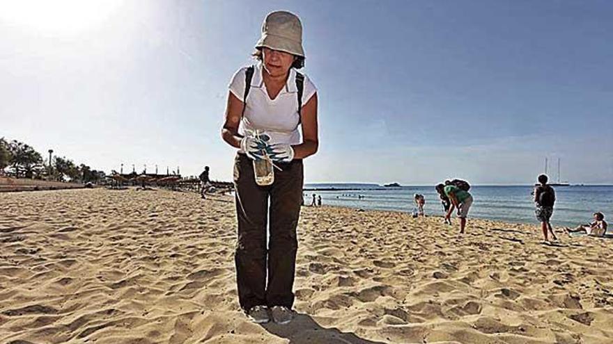 Una mujer participa en una recogida de colillas en el litoral.