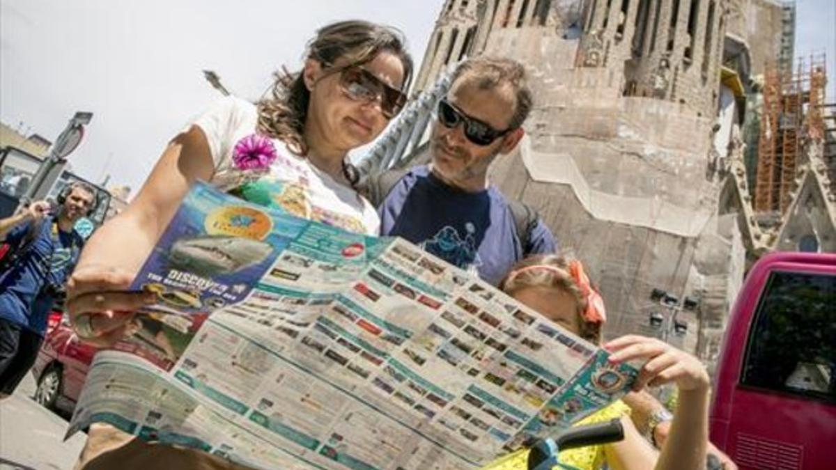 Unos turistas consultan un mapa en Barcelona el pasado junio.