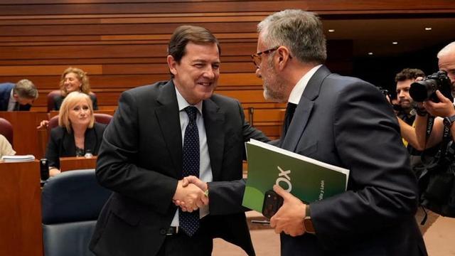 El presidente Alfonso Fernández Mañueco recibe el saludo del líder de Vox, Carlos Pollán, durante la sesión de ayer en el hemiciclo regional. | JOSÉ LUIS FERNÁNDEZ