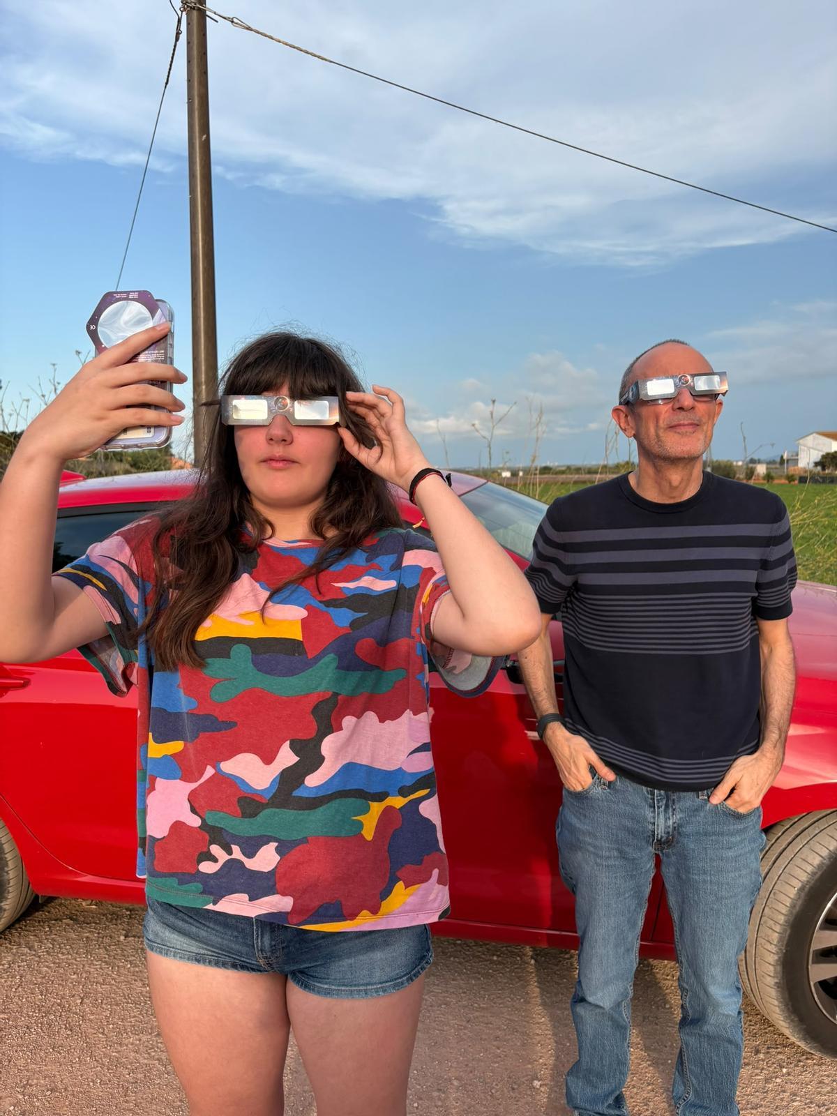 Una joven en Benifaió observa y fotografía el eclipse.