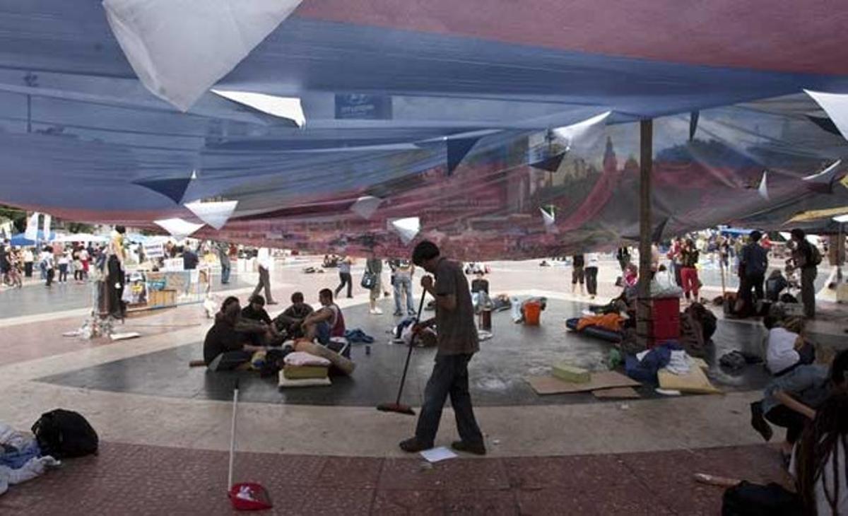 Un noi escombrant a la plaça de Catalunya, on segueixen acampats els indignats.
