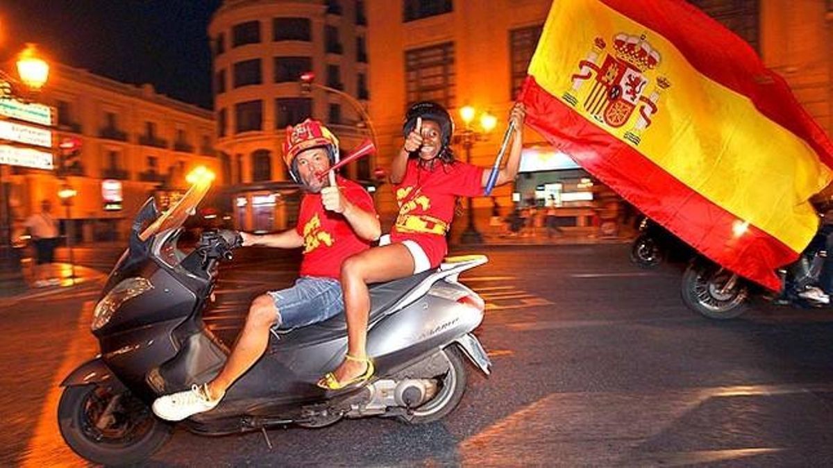 Una parella celebra pels carrers de València el pas a la final de la copa mundial de futbol.