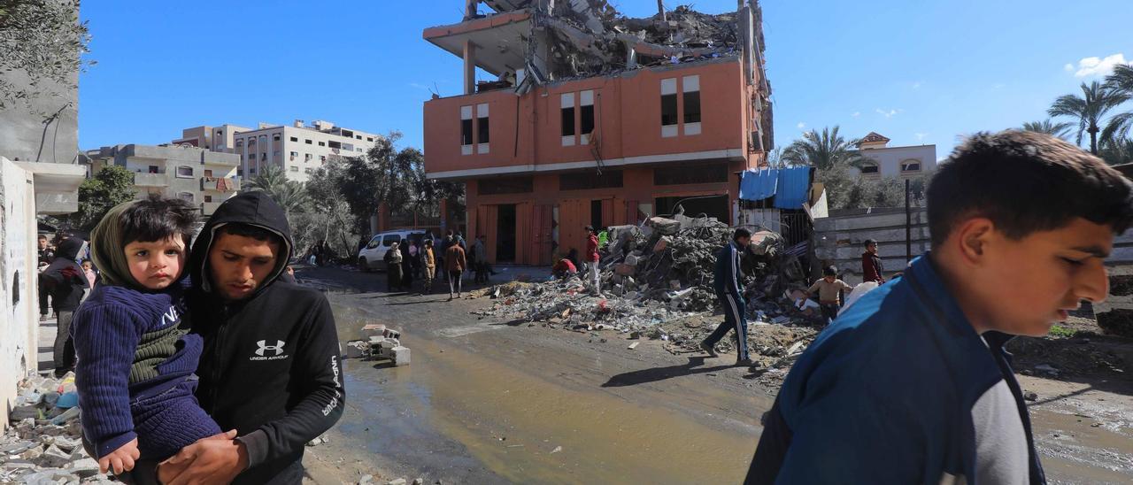 Palestinos inspeccionan las ruinas de un edificio destruido tras un bombardeo israelí en Dair El-Bakah, en la Franja de Gaza