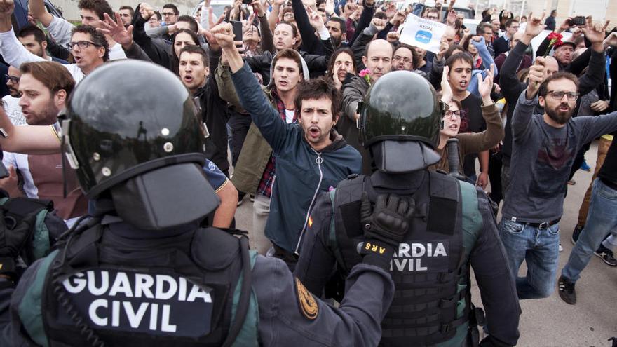 Guardias civiles frente a un grupo de manifestantes en un centro de votación del 1-O.