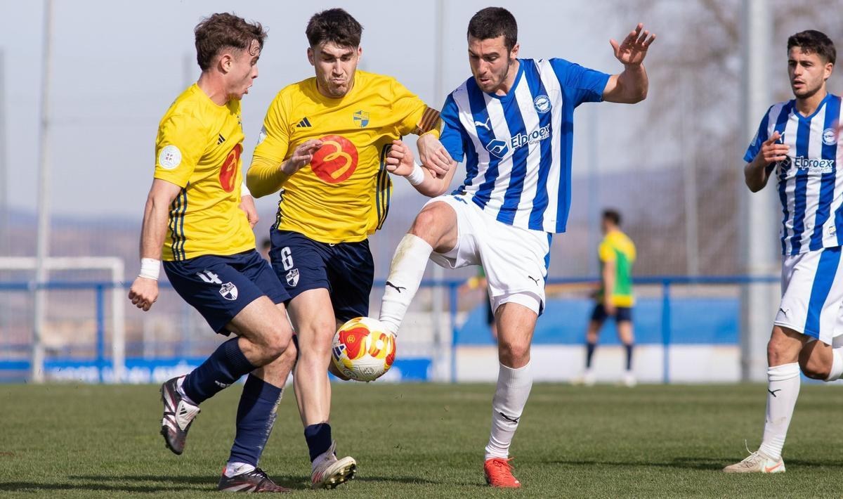 Dos jugadores del Ebro disputan un balón con uno del Alavés B.