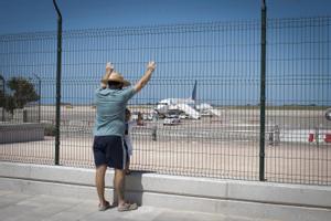  Varias personas observan aviones en aeropuerto de Menorca en el primer día del mes de julio de las vacaciones de verano. 