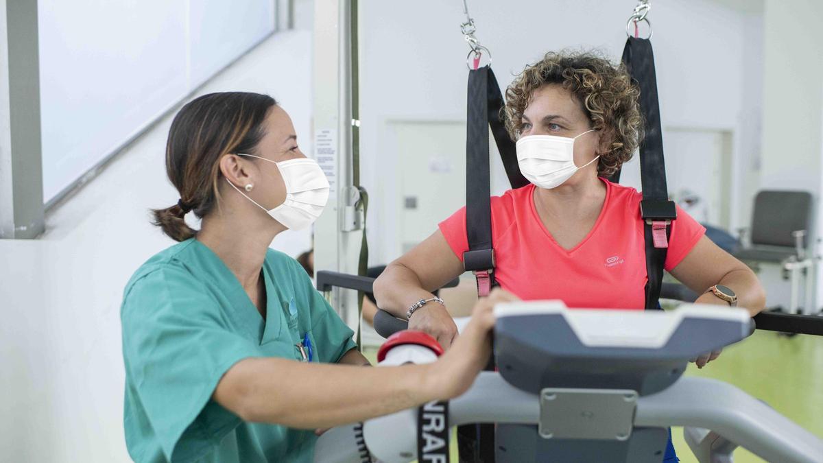 Los sanitarios del centro realizan terapia de rehabilitación a una paciente.