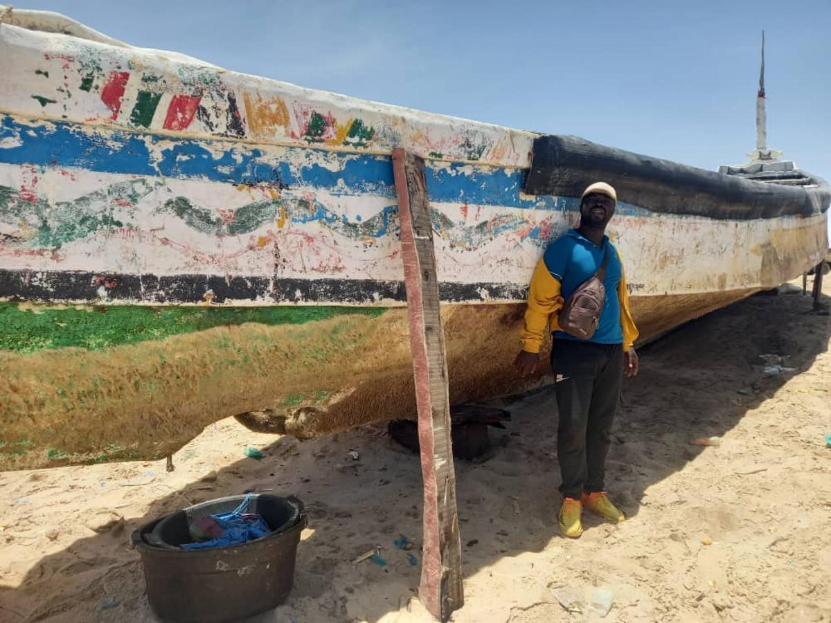 El marinero mauritano ante uno de los cayucos en donde trabaja en la pesca en su país.