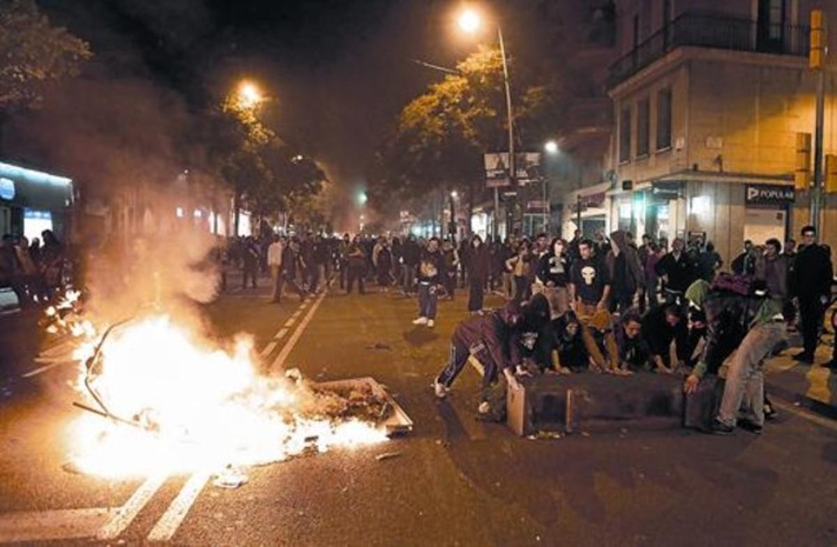 Un grup de manifestants cremen objectes al mig del carrer, ahir a la nit en Sants.