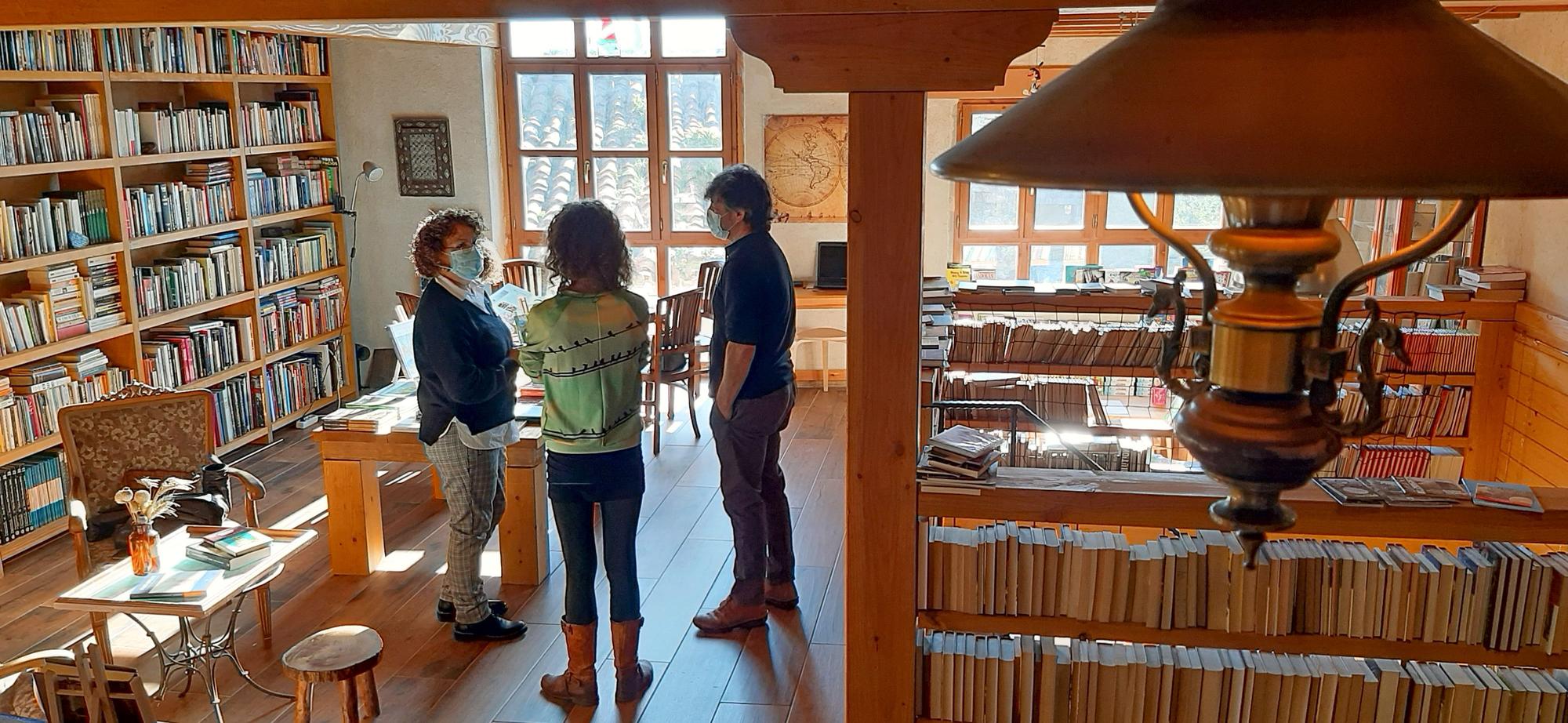 Esteban Raposo charla con dos viajeras que pasaron por su librería.
