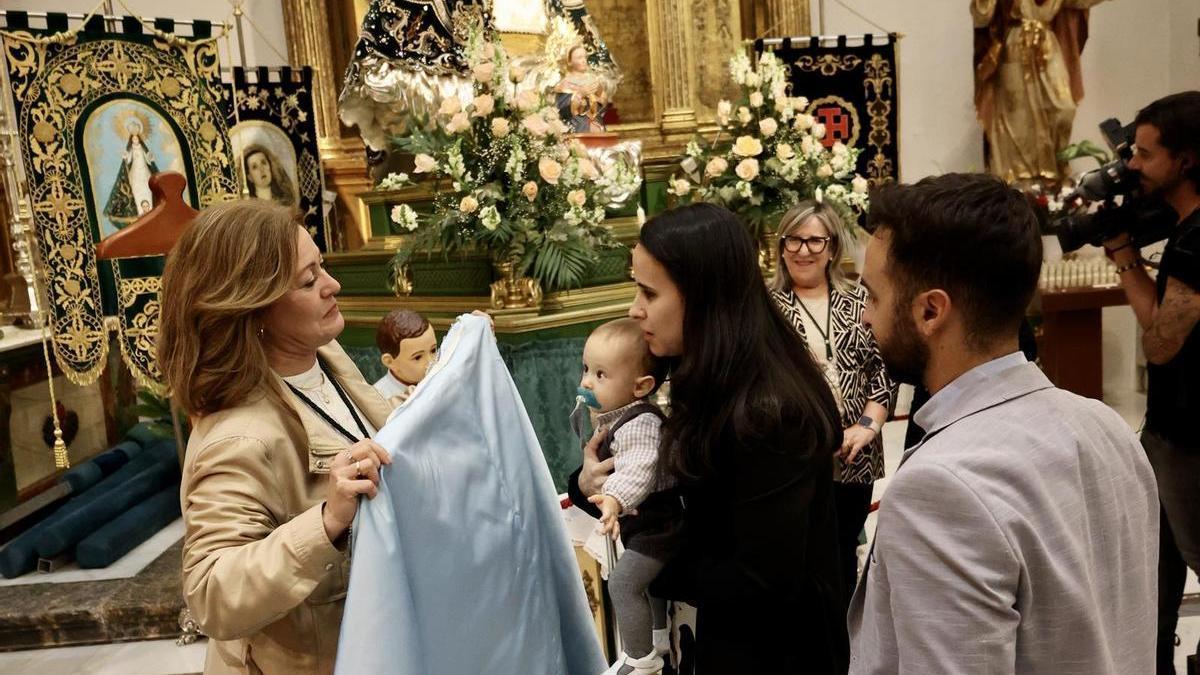 Paso de bebés y madres por el manto de la Virgen de la Esperanza, patrona de Calasparra, en la iglesia de San Miguel.