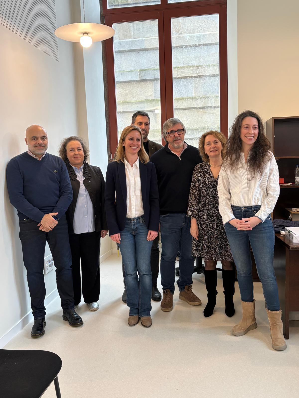 Maite Flores, en el centro, acompañada de alguno de los miembros de su equipo, en su local electoral en la Facultade de Medicina.