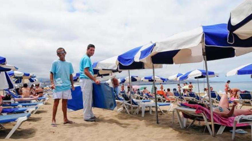 Los hamaqueros Alejandro D. Betancor y Manuel Gutiérrez, ayer, a la altura del hotel Reina Isabel. | sabrina ceballos