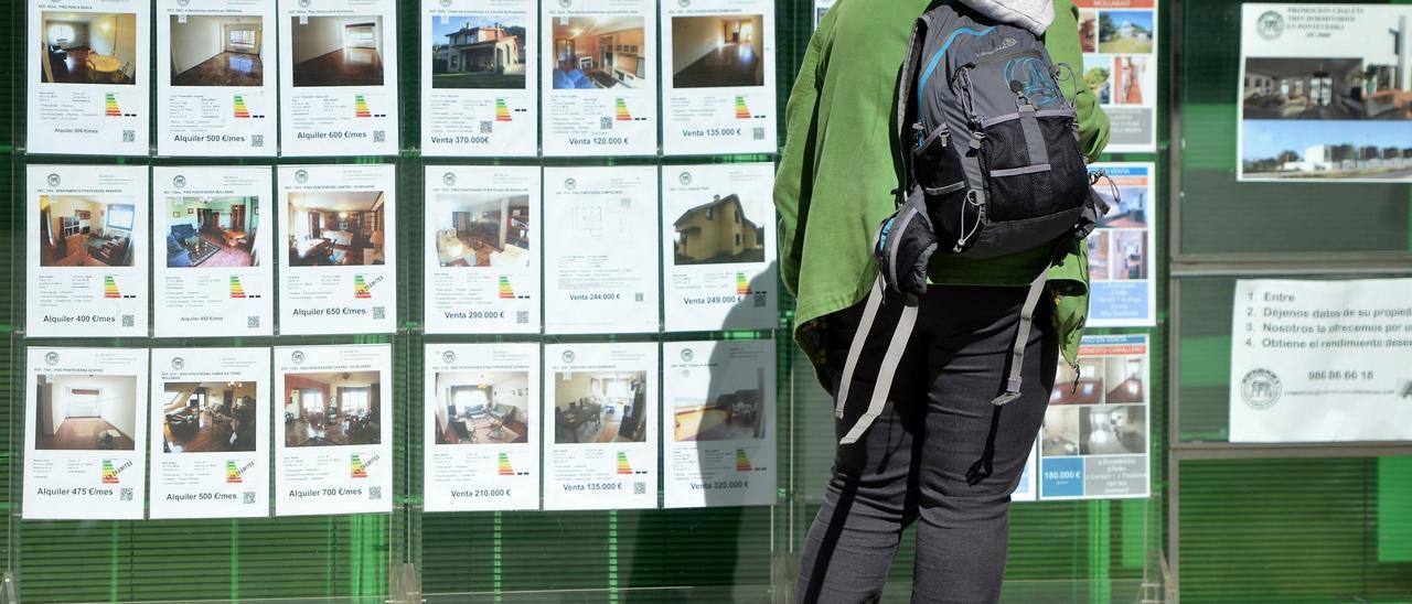 Un hombre pasa frente al escaparate de una inmobiliaria.