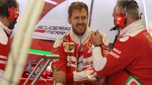 Sebastian Vettel dialoga con miembros del equipo Ferrari, en México.