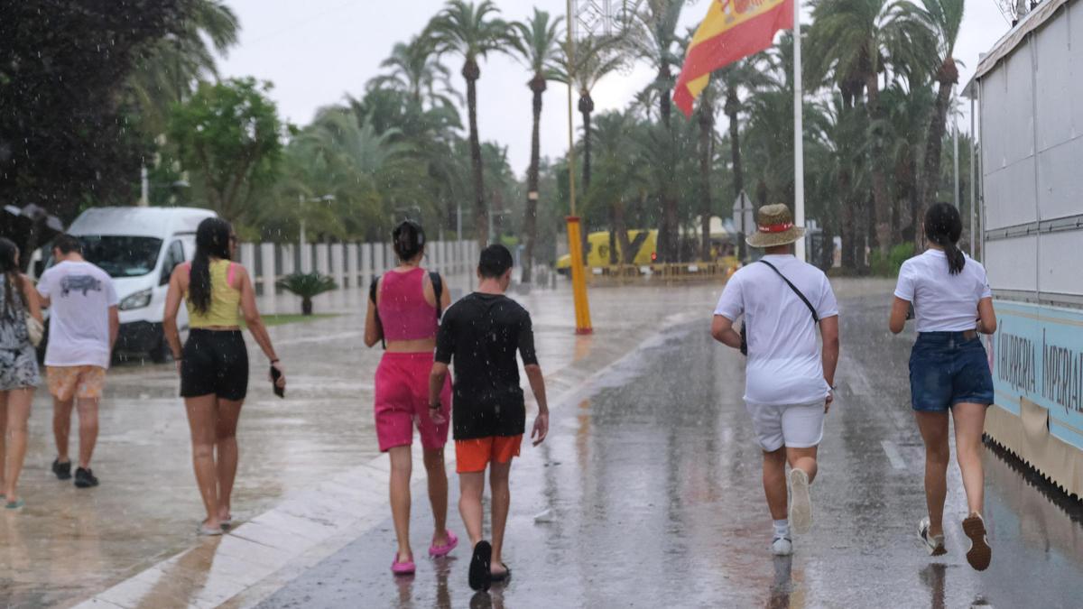 Varias personas tratándose de poner a cubierto en Elche el pasado miércoles día 14 tras comenzar a llover con fuerza repentinamente.