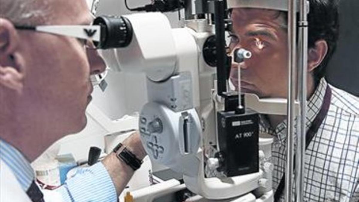 EXAMEN OCULAR. El doctor Josep Maria Caminal revisa la vista a un paciente en la consulta.
