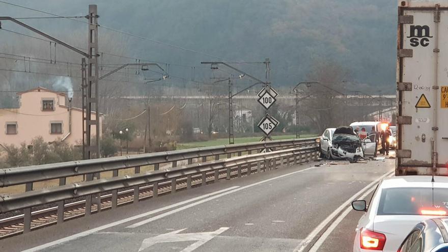 El cotxe ben destrossat de la part davantera a causa de la pèrdua de càrrega del camió