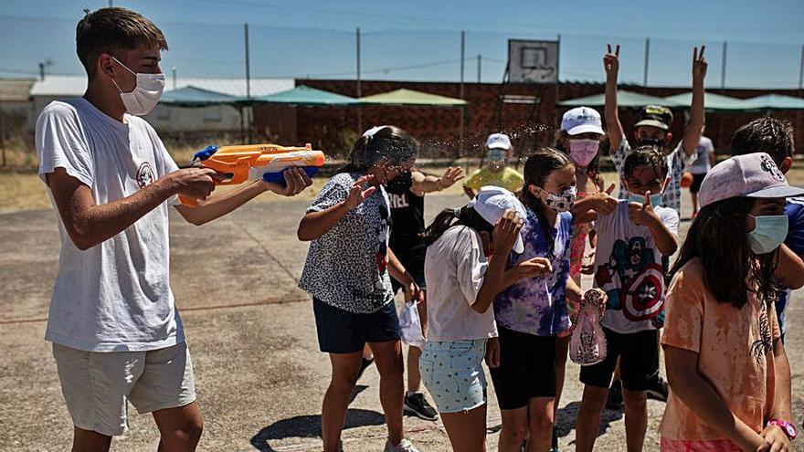 Uno de los monitores moja a los niños con una pistola de agua.