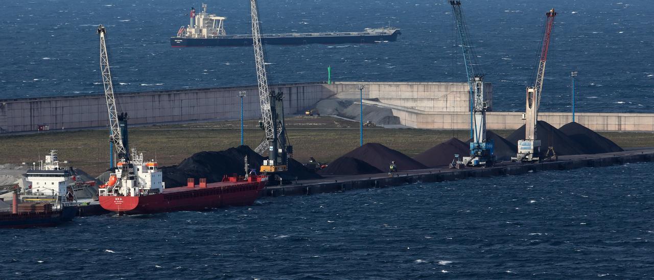 Dos buques atracados en el muelle Norte de El Musel, con otro fondeado a la espera de acceder al puerto, en segundo término.