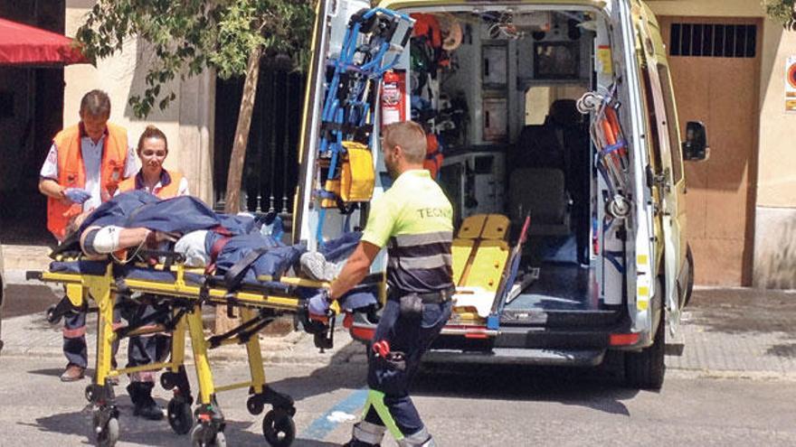 Efectivos sanitarios trasladan al trabajador herido, ayer en la plaza Sant Francesc, en Palma.