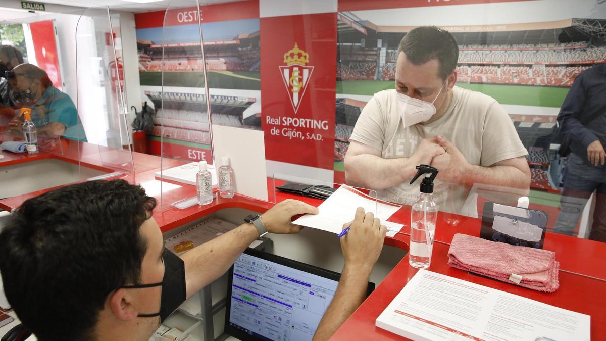 Un aficionado cursa su abono del Sporting para la presente temporada.