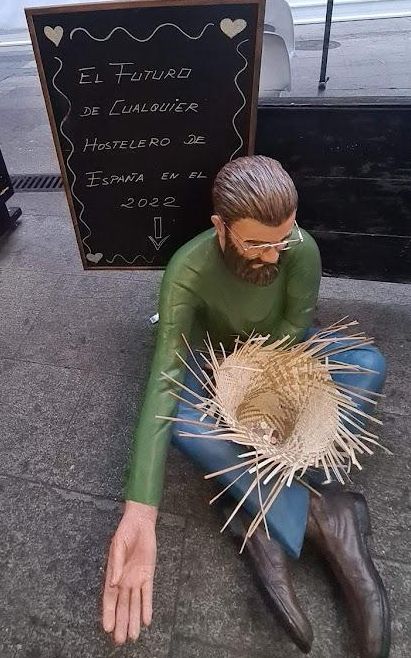 Una de las obras, con un letrero a su espalda alertando de la situación de la hostelería en España.