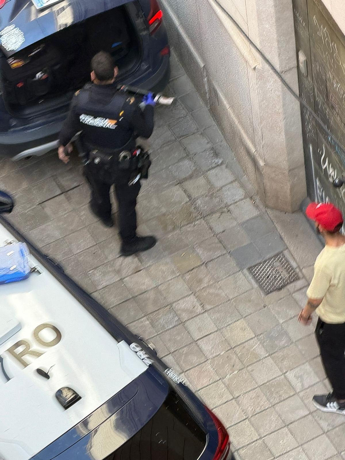 Un agente de policía sostiene el machete incautado a un hombre en la Xerea