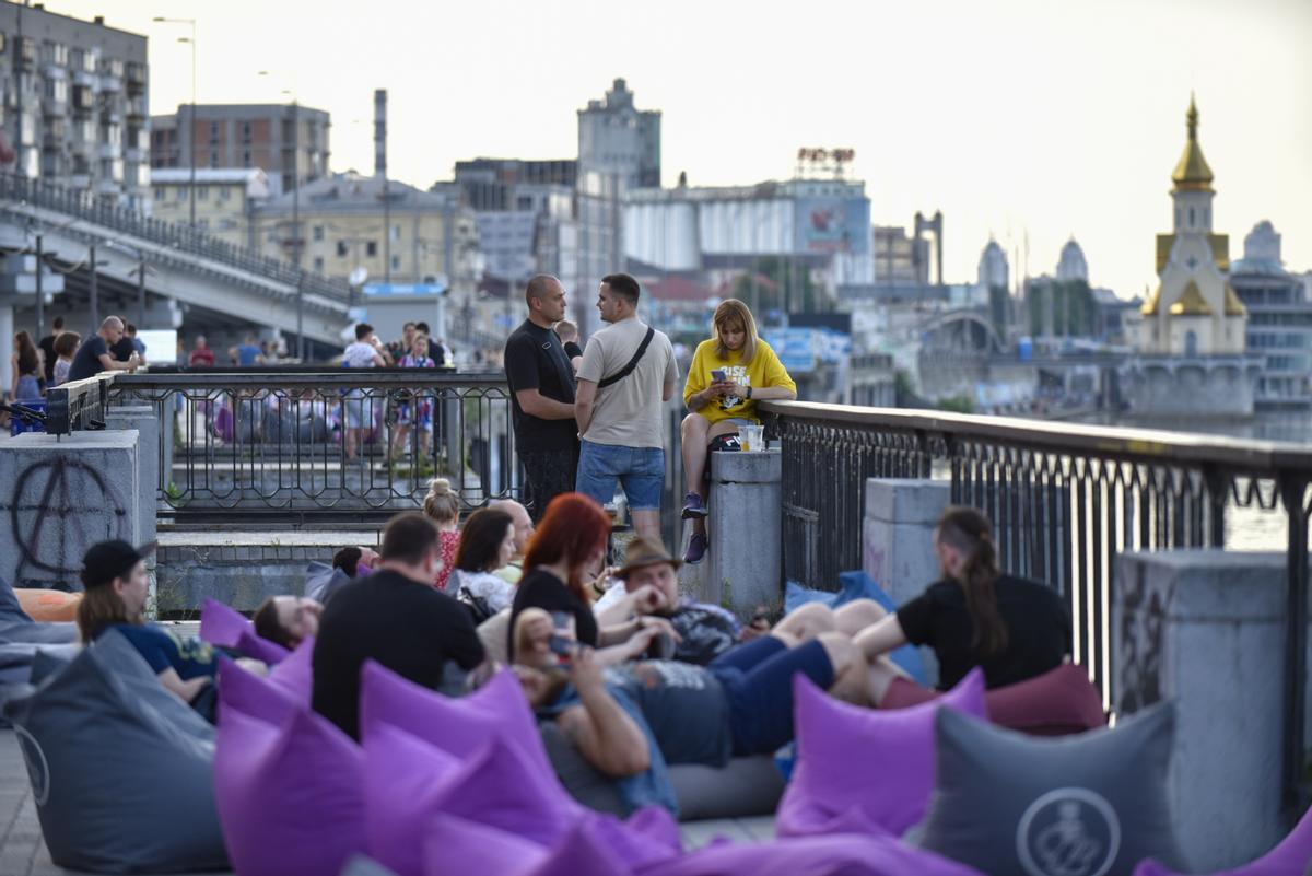 La gente pasa la noche al aire libre en un bar a orillas del río Dnipro en Kiev