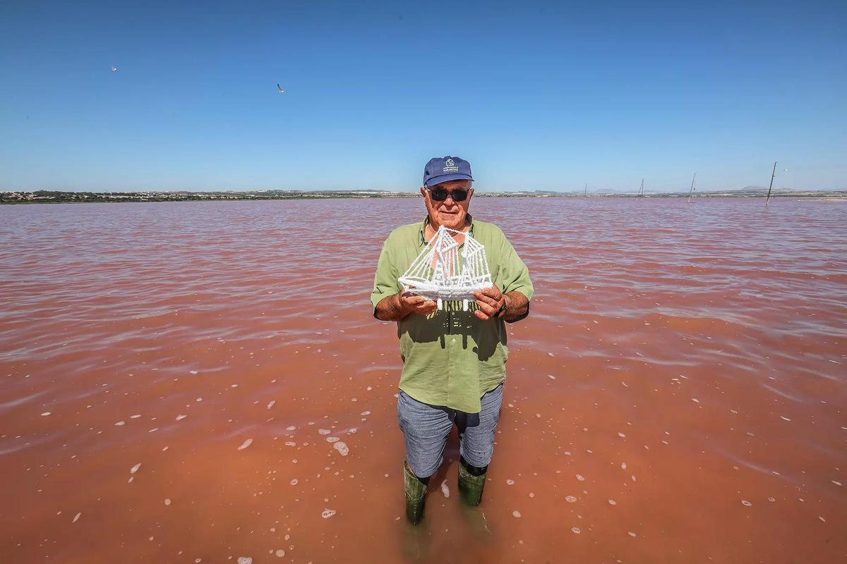 Artesano salinero con uno de sus barcos cuajados en sal, en una imagen de archivo