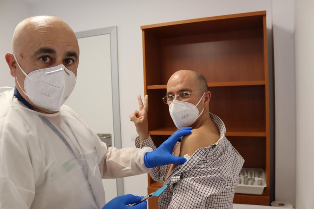 Salvador Oña Compán, 64 años, jefe de servicio de Medicina Preventiva del Hospital Regional, recibe la vacuna de la mano de Juan Vázquez Fernández, supervisor medicina preventiva.