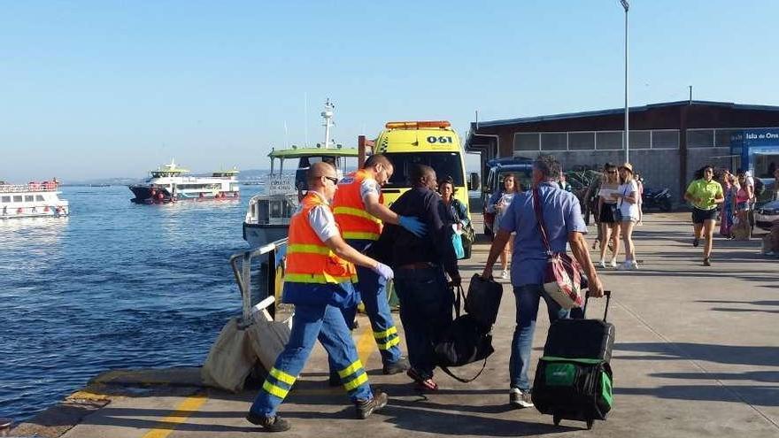 Los sanitarios acompañan al hombre a su llegada al puerto de Bueu. // Santos Álvarez