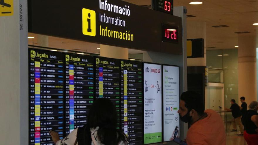 Dos viatgers consultant la pantalla on apareixen les arribades a l&#039;aeroport de Barcelona